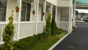 A multi-story hotel with white railings and potted plants on the balconies.