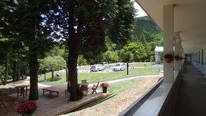 A view from a balcony overlooking a parking area with cars, a grassy lawn, and trees. - Family Lodge Hatagoya Hakone Sengokuhara (Hakone)