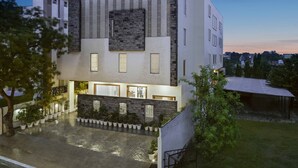 A modern building with a flat roof, large windows, and a stone facade.