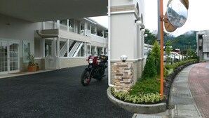 A building with a motorcycle parked in front, a staircase, and a landscaped area with plants. - Family Lodge Hatagoya Fujitsuru (Tsuru)