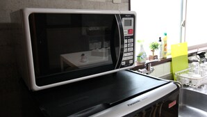 A microwave oven on a black countertop in a kitchen.