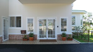 A building with a front entrance featuring a double glass door, a mailbox, and potted plants. - Family Lodge Hatagoya Kanazawa Uchinada (Uchinada)