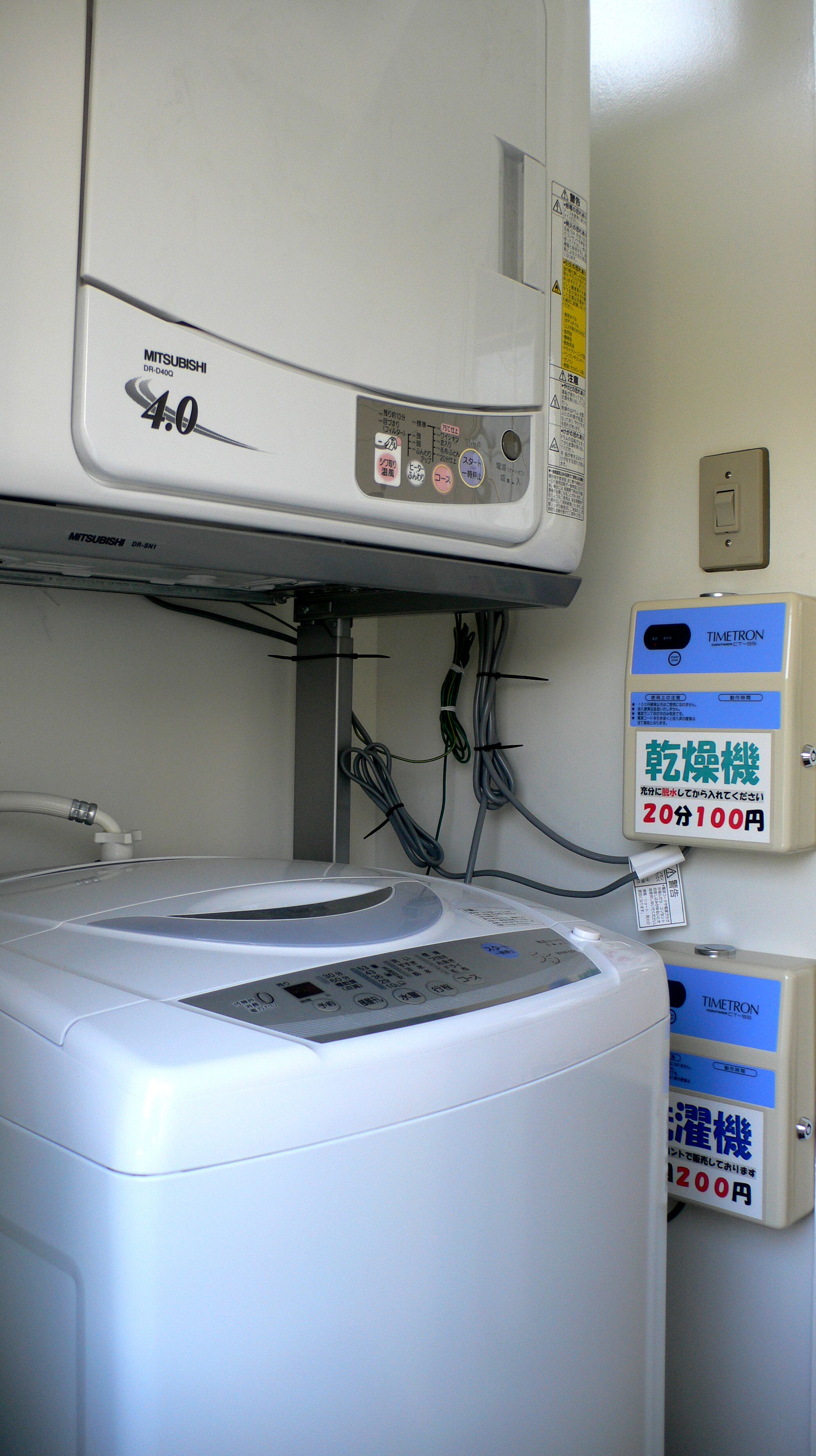 A washing machine with a control panel and a label indicating it is a Mitsubishi DR-D40Q model.