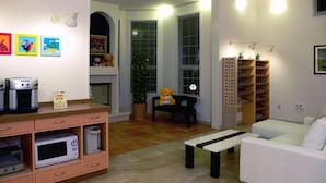 A living room with a sofa, a coffee machine, a microwave, a small table, a teddy bear, a bookshelf, and a potted plant. - Family Lodge Hatagoya Takamatsu (Takamatsu)