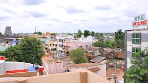 A hotel named KPA Rooms in a densely populated urban area with various buildings and a temple in the background. - KPA Grand Palace (Sriperumbudur)