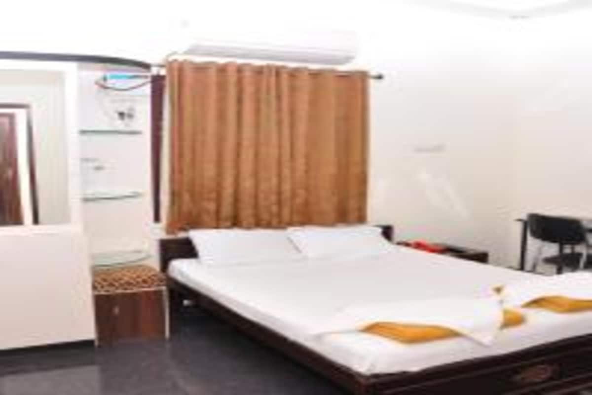 A hotel room with a bed, a desk, a chair, and a wardrobe.