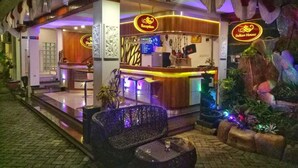 A hotel reception area with a modern design, including a reception desk, seating area, and decorative plants. - Sultan Guest House & Resto Tulungagung (Tulungagung)
