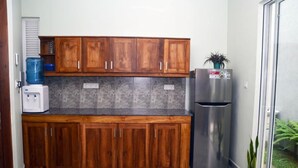 A kitchen with wooden cabinets, a stainless steel refrigerator, and a water dispenser. - Kelaniya Heritage (Kiribathgoda)