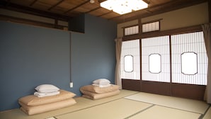 A traditional Japanese room with tatami flooring, a shoji screen door, and a ceiling light fixture. - Guest house tokonoma - Hostel (Kamijima)
