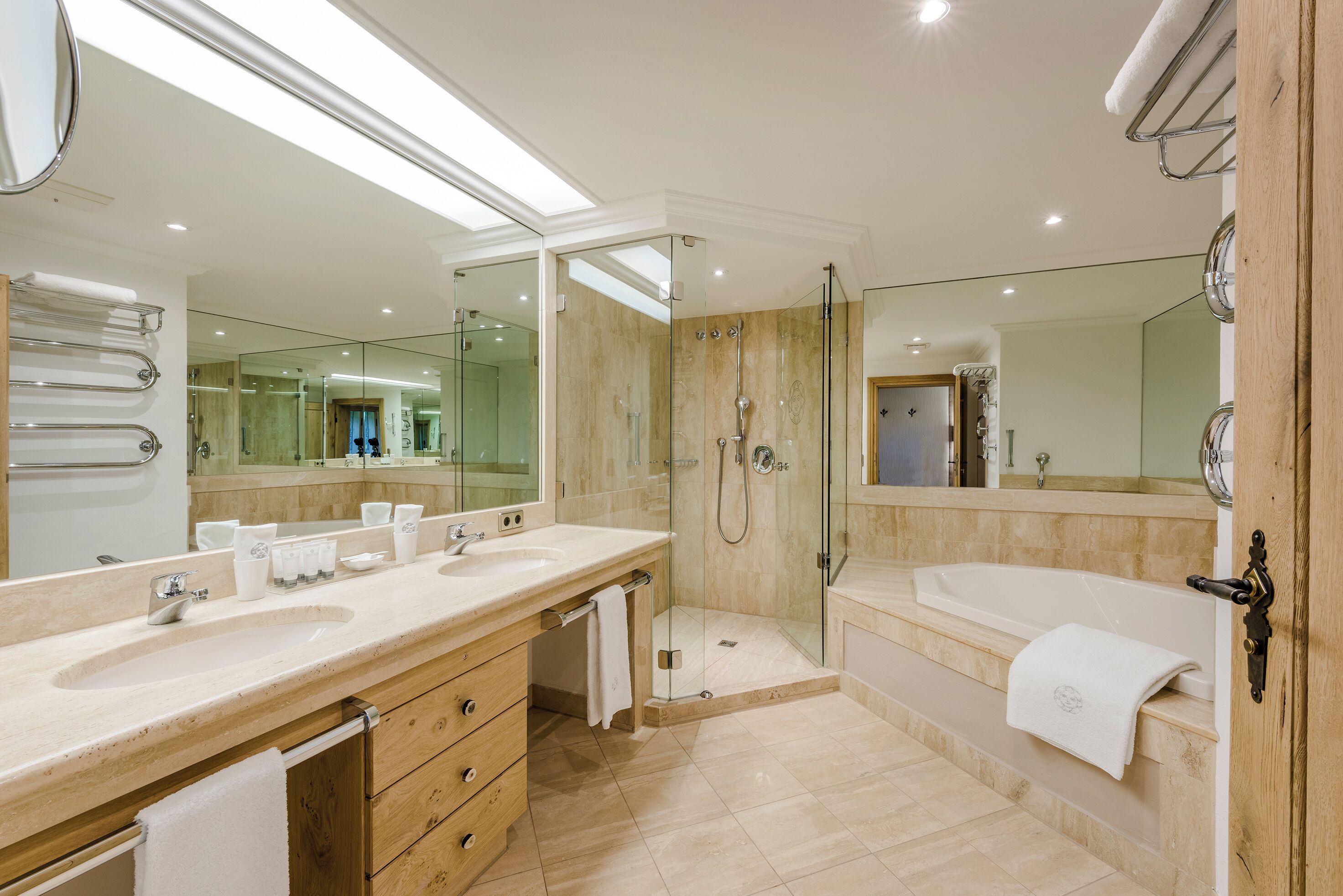 Une salle de bain moderne avec un grand lavabo, un miroir et une douche à l’italienne.