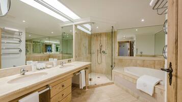 Une salle de bain moderne avec un grand lavabo, un miroir et une douche à l’italienne.