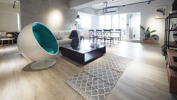 A spacious living area with a modern sofa, a unique egg-shaped chair, a glass coffee table, and a dining area with chairs and a table. - SOGO Dept. Zhongxiao Fuxing MRT (Taipei)
