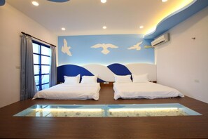 A modern hotel room with two beds, a large window with curtains, a wall mural with birds, and a built-in aquarium. - Easy Stay B&B (Magong)