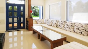 A modern living room with a sofa set, a coffee table, and a blue door. - Easy Stay B&B (Magong)