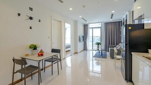 A modern kitchen with a refrigerator, dining table, and chairs.