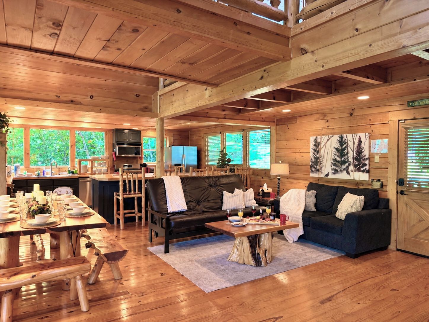 A wooden cabin interior with a dining area, a sofa, a coffee table, and a kitchen area with a refrigerator and microwave.