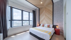 A modern hotel room with a large window, a bed with patterned bedding, a red nightstand, and a wooden ceiling. - OYO Home 89396 Indescribable 3br Arte Plus (Kuala Lumpur)
