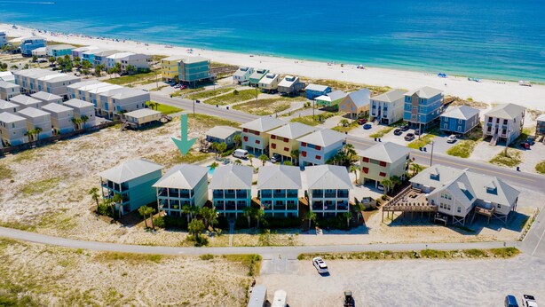 A coastal residential area with beachfront properties, a road, and a beach. - Lagoon Views | Steps to Gulf Access | Community Pool and Pier (gulf shores)