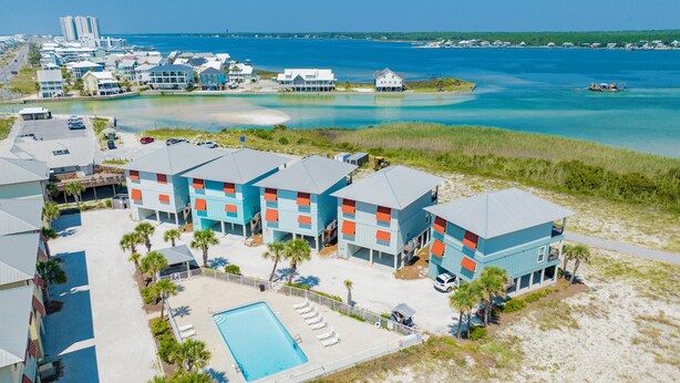 Ein Resort mit mehreren Gebäuden, einem Schwimmbad und Blick auf den Strand.