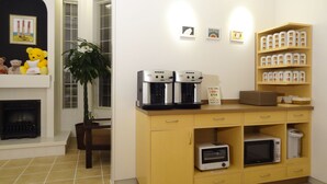 A kitchen with a coffee machine, microwave, and storage cabinets. - Family Lodge Hatagoya Tsuyama (Tsuyama)