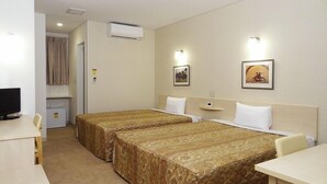 Una habitación de hotel con dos camas, un escritorio, televisión y baño.