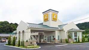 A hotel with a central tower, a covered entrance, and a parking lot. - Family Lodge Hatagoya Niihama (Niihama)