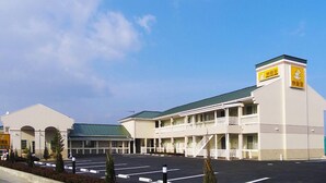 A hotel with a central building and a smaller annex. It features a parking lot and a clear sky. - Family Lodge Hatagoya Fukuroi (Fukuroi)