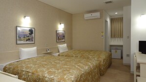 A hotel room with two beds, a desk, a TV, and an air conditioning unit. - Family Lodge Hatagoya Fukuroi (Fukuroi)