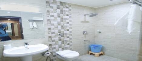 A bathroom with a sink, toilet, and shower.