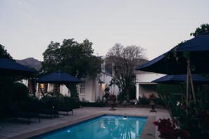 Una piscina al aire libre, camas de piscina gratis, sombrillas