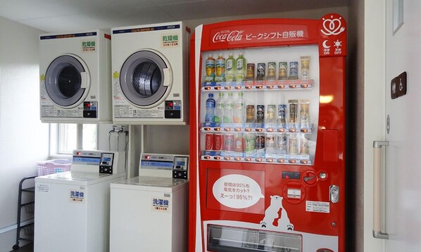 A laundromat with multiple washing machines and a Coca-Cola vending machine. - Family Lodge Hatagoya Tottori Kurayoshi (Yurihama)