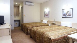 Quarto de hotel com duas camas, uma escrivaninha, televisão e uma kitchenette pequena.