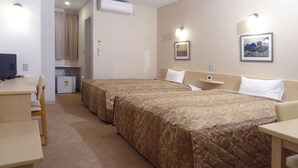 Een hotelkamer met twee bedden, een bureau, een stoel, een kleine koelkast en een schilderij aan de muur.