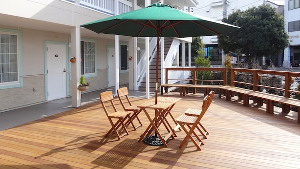 A wooden deck with outdoor seating and a green umbrella.
