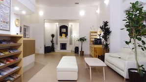 A modern living room with a fireplace, a sofa, a coffee table, and a bookshelf.