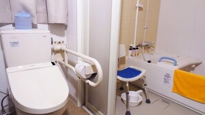 Separat badekar og bruser, hårtørrer, et toilet med elektronisk bidet