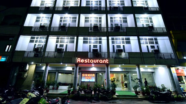 A multi-story building with a prominent 'Silver Inn' sign, balconies, and a 'Restaurant' sign.