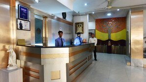 A reception desk with a statue, a framed picture, and a ceiling fan.