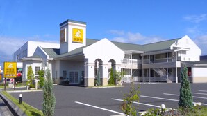 Un hôtel doté d’une entrée principale, de nombreux balcons et d’un parking.