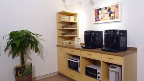 A kitchenette with a microwave, toaster, and coffee maker, a potted plant, and a framed picture on the wall. - Family Lodge Hatagoya Matsuyama (Matsuyama)