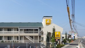 A multi-story hotel with a green roof, white balconies, and a sign indicating it is a ryokan. - Family Lodge Hatagoya Sanuki Kanonji (Kanonji)