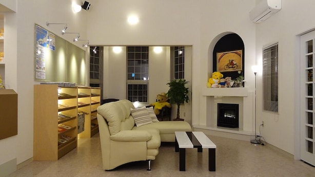 A living room with a sofa, a coffee table, a fireplace, a bookshelf, and a window. - Family Lodge Hatagoya Izumo Taisha (Izumo)