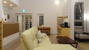 Aula, jossa on sohva, kahvinkeitin ja työpöytä.