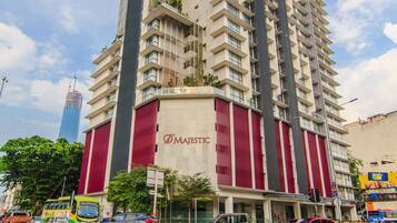 A high-rise building with a prominent 'Majestic' sign, featuring a modern architectural design with a mix of glass and solid panels, located in an urban setting with visible traffic and other buildings in the background.