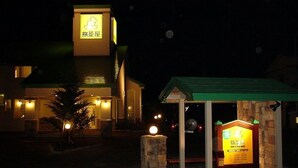 A building with a signboard and a small structure with a green roof. - Family Lodge Hatagoya Akita Rokugo (Misato)