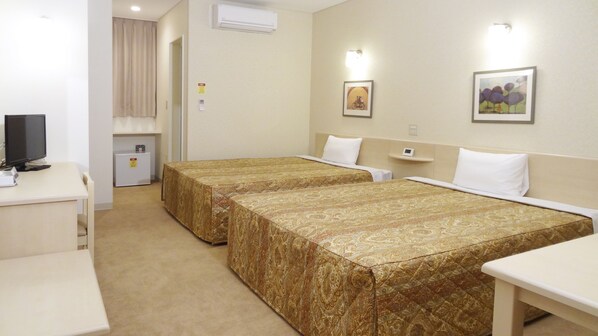 A hotel room with two beds, a desk with a computer, a small fridge, and a television. - Family Lodge Hatagoya Chino Tateshina (Chino)