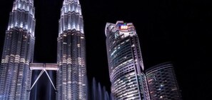 Vue nocturne des tours Petronas, avec les bâtiments modernes qui les entourent.