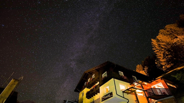 Un edificio con varios balcones y una escalera que lleva a la entrada.