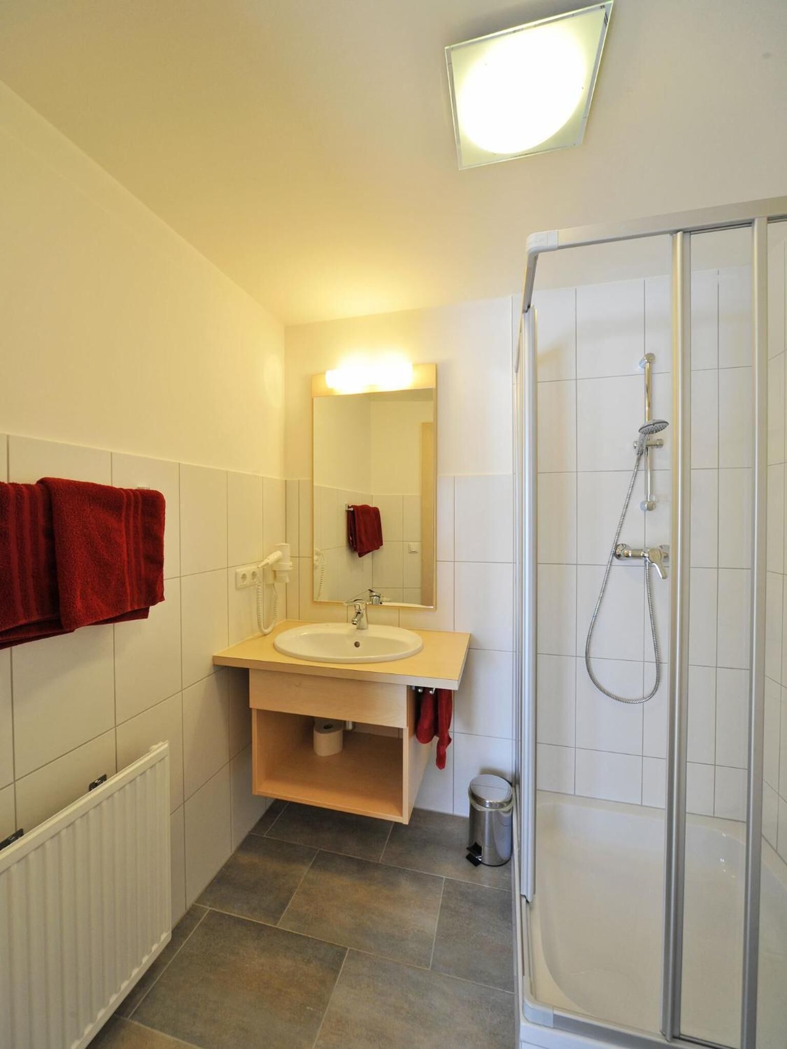 Un baño moderno con ducha, lavabo y espejo.