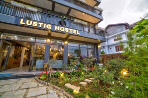 A hostel named "Lustig Hostel" with a modern design, outdoor garden, and visible interior including a reception area. - Lustig Hostel (Sa Pa)